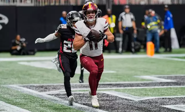 Washington Commanders wide receiver Luke McCaffrey (11) scores a touchdown past Atlanta Falcons cornerback Dee Alford (20) during the first half of an NFL football game, Sunday, Sept. 28, 2025, in Atlanta. (AP Photo/Mike Stewart)