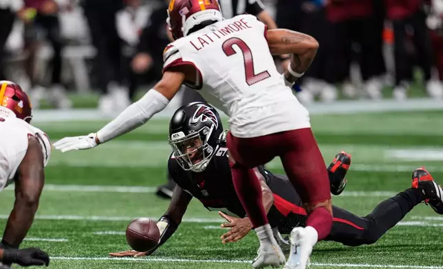 Atlanta Falcons quarterback Michael Penix Jr., below, recovers a fumble during the first half of an NFL football game against the Washington Commanders, Sunday, Sept. 28, 2025, in Atlanta. (AP Photo/Mike Stewart)