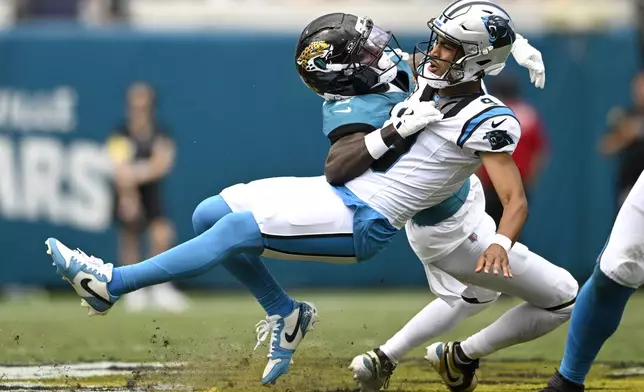 Jacksonville Jaguars cornerback Jourdan Lewis (2) tackles Carolina Panthers quarterback Bryce Young (9) during the first half of an NFL football game, Sunday, Sept. 7, 2025, in Jacksonville, Fla. (AP Photo/Phelan M. Ebenhack)