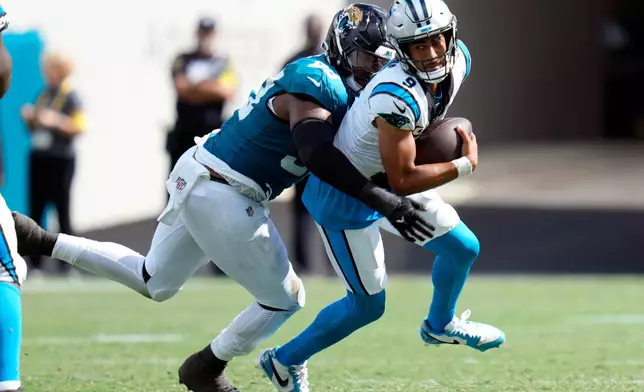 Jacksonville Jaguars defensive end Dawuane Smoot, left, sacks Carolina Panthers quarterback Bryce Young (9) during the second half of an NFL football game, Sunday, Sept. 7, 2025, in Jacksonville, Fla. (AP Photo/John Raoux)