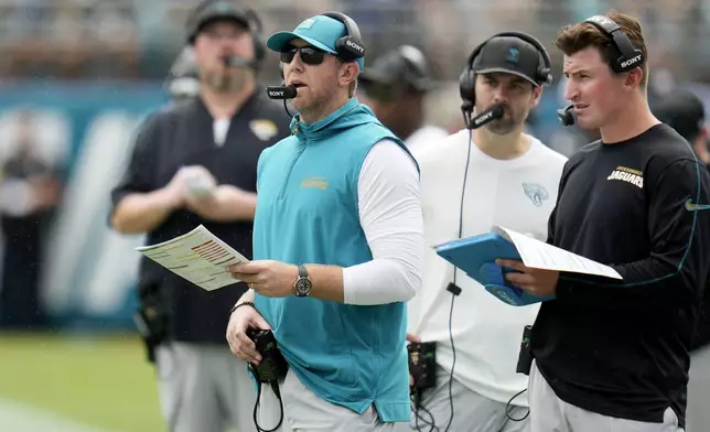 Jacksonville Jaguars head coach Liam Coen, front left, looks on during the first half of an NFL football game against the Carolina Panthers, Sunday, Sept. 7, 2025, in Jacksonville, Fla. (AP Photo/John Raoux)