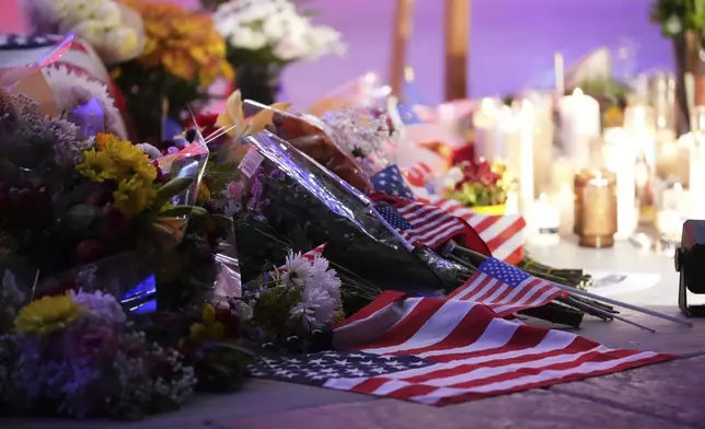 Flowers, candles and American flags sit at a vigil for Charlie Kirk, the CEO and co-founder of Turning Point USA who was shot and killed, Thursday, Sept. 11, 2025, in Orem, Utah. (AP Photo/Lindsey Wasson)