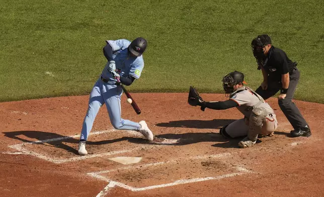 Toronto Blue Jays outfielder Joey Loperfido, left, hits an RBI double in front of Baltimore Orioles catcher Alex Jackson, second from right, during sixth-inning baseball game action in Toronto, Sunday, Sept. 14, 2025. (Chris Young/The Canadian Press via AP)