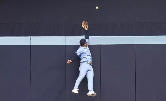 Toronto Blue Jays outfielder Daulton Varsho leaps to try to catch a solo home run hit by Baltimore Orioles' Coby Mayo during second-inning baseball game action in Toronto, Sunday, Sept. 14, 2025. (Chris Young/The Canadian Press via AP)