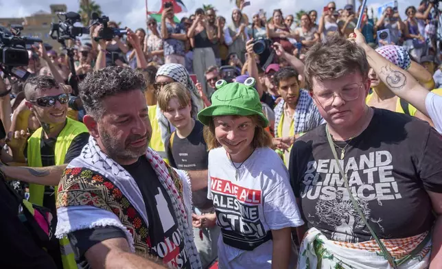 Swedish climate activist Greta Thunberg, center, arrives to board a boat taking part in a civilian flotilla bound for Gaza, aiming to break the Israeli blockade and deliver humanitarian aid, in Barcelona, Spain, Sunday, Aug. 31, 2025. (AP Photo/Emilio Morenatti)