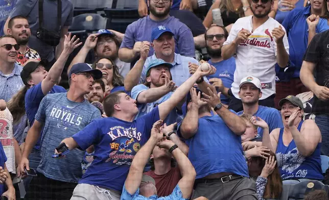 Fans try to catch a foul ball hit by Detroit Tigers' Andy Ibanez during the eighth inning of a baseball game against the Kansas City Royals, Sunday, Aug. 31, 2025, in Kansas City, Mo. (AP Photo/Charlie Riedel)
