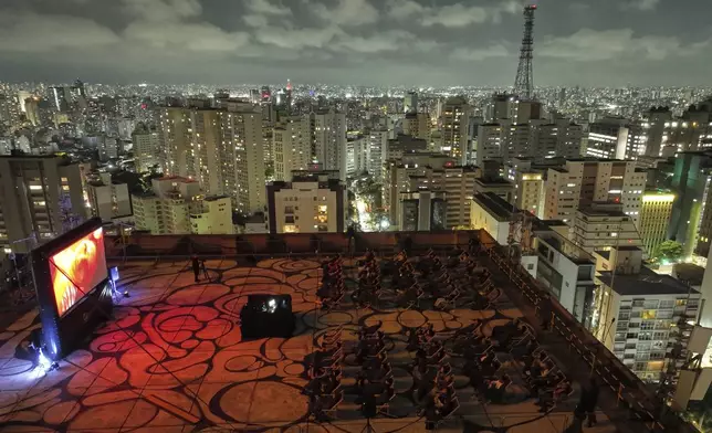 People watch 'A Star Is Born' at an open-air movie theater on the rooftop of a shopping mall on Paulista Avenue in Sao Paulo, Saturday, Aug. 30, 2025. (AP Photo/Andre Penner)