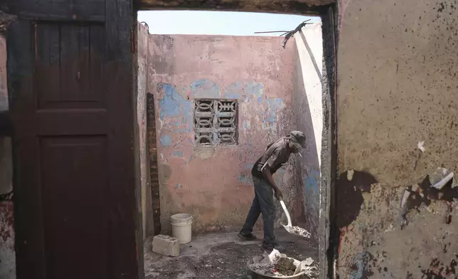 Francick Ferolis cleans his house after it was damaged by gang violence in the Solino neighborhood of Port-au-Prince, Haiti, Wednesday, Sept. 10, 2025. (AP Photo/Odelyn Joseph)