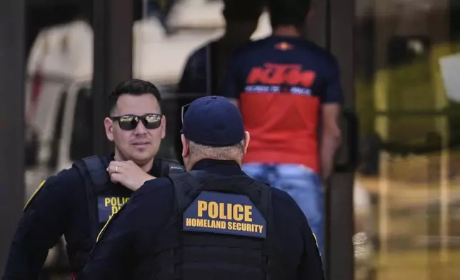 Department of Homeland Security police officers are stationed at the front door of the U.S. Immigration and Customs Enforcement regional field office, Tuesday, Sept. 16, 2025, in Burlington, Mass. (AP Photo/Charles Krupa)