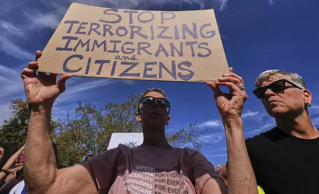 Protesters gather outside the U.S. Immigration and Customs Enforcement regional field office, Tuesday, Sept. 16, 2025, in Burlington, Mass. (AP Photo/Charles Krupa)