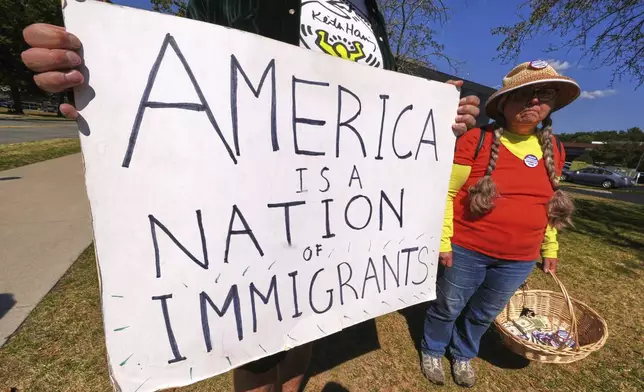 Protesters picket outside the U.S. Immigration and Customs Enforcement regional field office, Thursday, Sept. 11, 2025, in Burlington, Mass. (AP Photo/Charles Krupa)