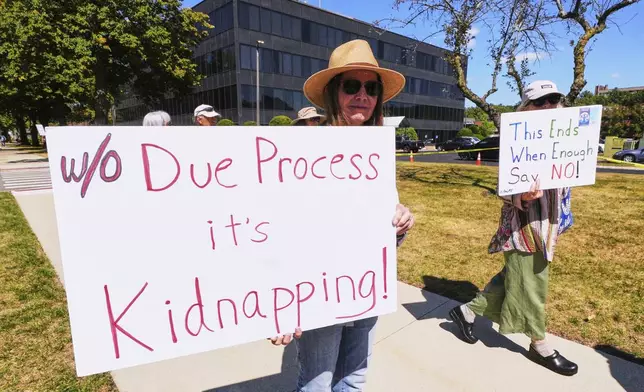 Protesters picket outside the U.S. Immigration and Customs Enforcement regional field office, Thursday, Sept. 11, 2025, in Burlington, Mass. (AP Photo/Charles Krupa)
