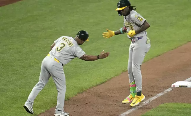 Athletics' Lawrence Butler, right, is greeted by third base coach Eric Martins (3) as he rounds third after hitting a three-run home run off Pittsburgh Pirates pitcher Mitch Keller during the fifth inning of a baseball game in Pittsburgh, Friday, Sept. 19, 2025. (AP Photo/Gene J. Puskar)