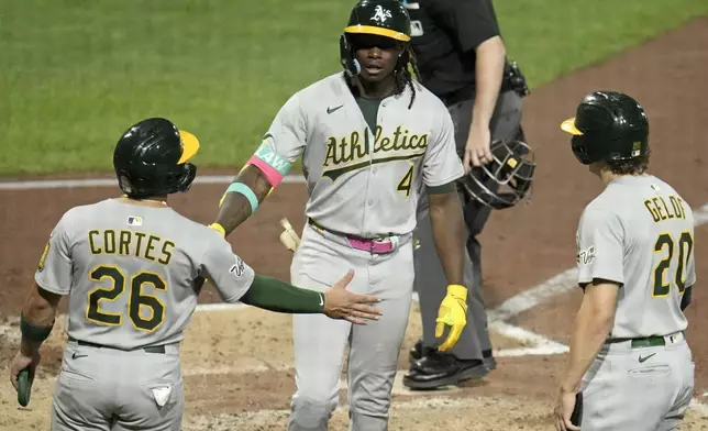 Athletics' Lawrence Butler (4) is greeted by Carlos Cortes (26) and Zack Gelof, right, as he heads to the dugout after hitting a three-run home run off Pittsburgh Pirates pitcher Mitch Keller during the fifth inning of a baseball game in Pittsburgh, Friday, Sept. 19, 2025. (AP Photo/Gene J. Puskar)