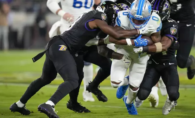 Detroit Lions running back Jahmyr Gibbs (0) is tackled by a host of Baltimore Ravens defenders during the first half of an NFL football game Monday, Sept. 22, 2025, in Baltimore. (AP Photo/Stephanie Scarbrough)