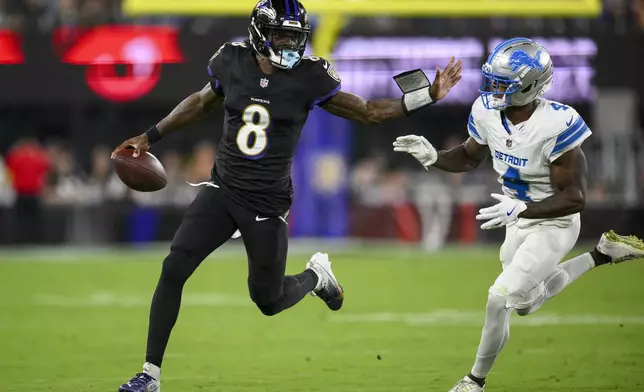 Baltimore Ravens quarterback Lamar Jackson (8) runs the ball as Detroit Lions cornerback DJ. Reed (4) tries to stop him during the first half of an NFL football game Monday, Sept. 22, 2025, in Baltimore. (AP Photo/Nick Wass)