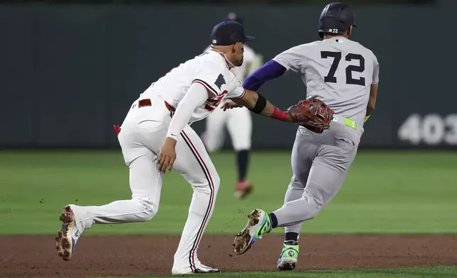 Minnesota Twins third baseman Royce Lewis, left, tags out New York Yankees' José Caballero (72) during the fifth inning of baseball game Monday, Sept. 15, 2025, in Minneapolis. (AP Photo/Matt Krohn)