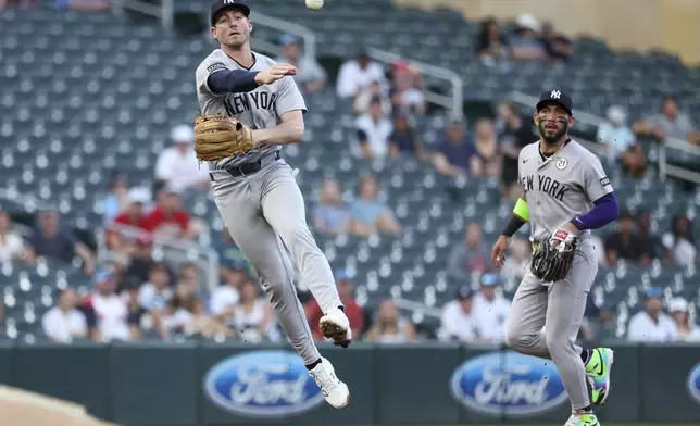New York Yankees third baseman Ryan McMahon, left, throws to first base to put out Minnesota Twins' Luke Keaschall during the first inning of baseball game Monday, Sept. 15, 2025, in Minneapolis. (AP Photo/Matt Krohn)