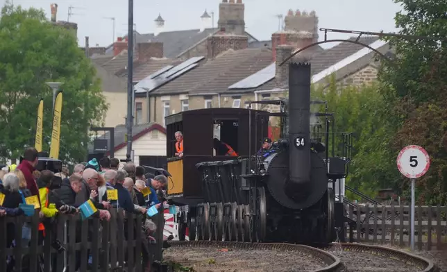 Railway enthusiasts gather on the trackside near to replica Locomotion No1 ahead of its first official journey in 200 years from the Locomotion Museum in Shildon to Darlington, Friday, Sept. 26, 2025 as part of celebrations marking the 200th anniversary of British passenger rail services. Picture date: Friday September 26, 2025. PA Photo. Photo credit should read: Owen Humphreys/PA Wire /PA via AP)