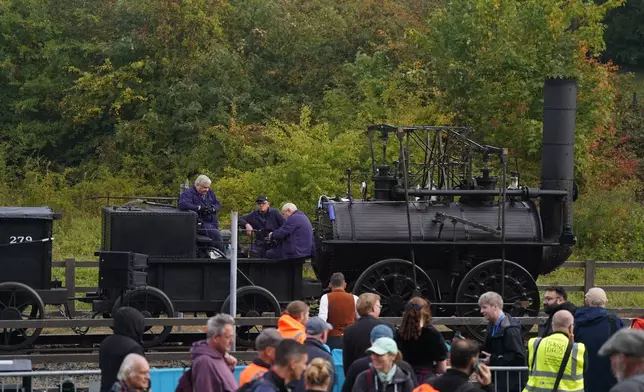 Railway enthusiasts look at the Locomotion No 1 replica as it is prepared at the Locomotion Museum in Shildon, County Durham, Friday, Sept. 26, 2025, on its first official journey in 200 years from the Locomotion Museum in Shildon to Darlington, as part of celebrations marking the 200th anniversary of British passenger rail services. (Owen Humphreys/PA via AP)