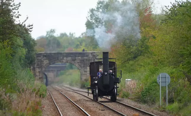 Replica Locomotion No1 approaches Heighington station, County Durham, Friday, Sept. 26, 2025, on its first official journey in 200 years from the Locomotion Museum in Shildon to Darlington, as part of celebrations marking the 200th anniversary of British passenger rail services. (Owen Humphreys/PA via AP)