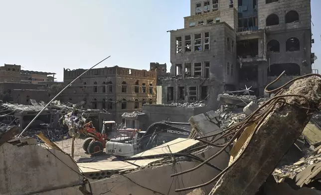 Workers use heavy machinery to clear rubble from buildings destroyed in Wednesday's Israeli airstrikes in Sanaa, Yemen, Saturday, Sept. 13, 2025. (AP Photo/Osamah Abdulrahman)