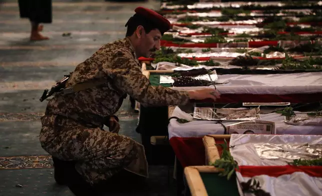 A Houthi officer mourns over a coffin of one of 31 local journalists reportedly killed in Israeli airstrikes last week, during their funeral inside the Shaab Mosque in Sanaa, Yemen, Tuesday, Sept. 16, 2025. (AP Photo/Osamah Abdulrahman)