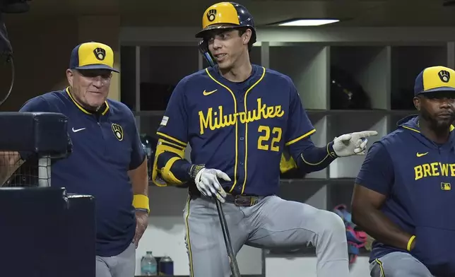 Milwaukee Brewers' Christian Yelich (22) talks with manager Pat Murphy in the dugout during the fourth inning of a baseball game against the San Diego Padres Monday, Sept. 22, 2025, in San Diego. (AP Photo/Gregory Bull)