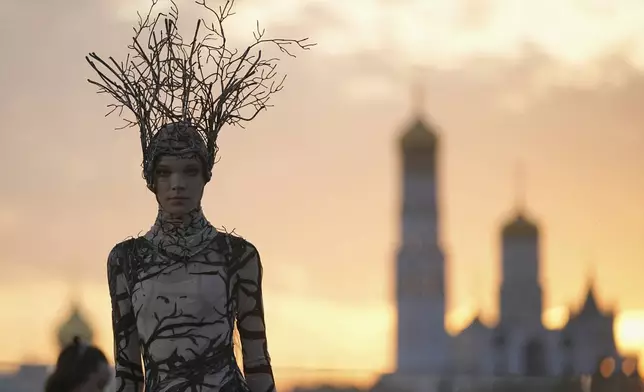 A model wears a creation by Russian brand Mandragora on a runway at the Moscow Fashion Week on the Floating Bridge at Zaryadye park in Moscow, Russia, Friday, Aug. 29, 2025, with the Kremlin in the background. (AP Photo/Pavel Bednyakov)
