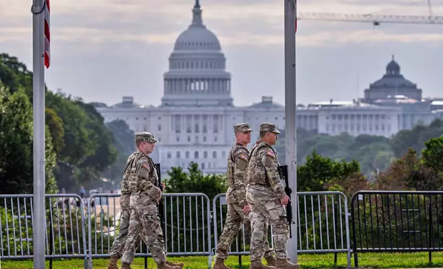 National Guard troops patrol the grounds of the Washington Monument with the Capitol seen in the distance as part of President Donald Trump's order to impose federal law enforcement in the nation's capital, in Washington, Thursday, Aug. 28, 2025. (AP Photo/J. Scott Applewhite)