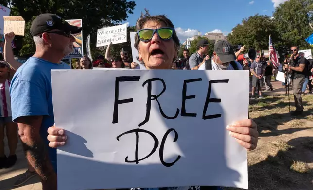 Becky Mascal, holds a banner as demonstrators protest against President Donald Trump's use of federal law enforcement and National Guard troops in the city at the White House Tuesday, Sept. 2, 2025, in Washington. (AP Photo/Manuel Balce Ceneta)