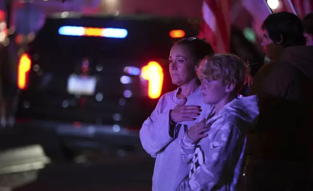 Attendees look on during a procession Wednesday, Sept. 17, 2025, in Spring Grove, Pa., after multiple police officers were shot and killed. (AP Photo/Matt Slocum)
