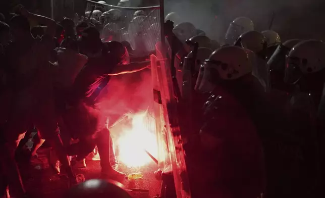 Anti-government protesters clash with riot police during a protest against increasing police brutality in the northern Serbian city of Novi Sad, Friday, Sept. 5, 2025. (AP Photo/Darko Vojinovic)