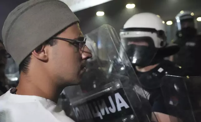 A man wearing a traditional Serbian hat stands in front of riot police cordon during a protest against increasing police brutality in the northern Serbian city of Novi Sad, Friday, Sept. 5, 2025. (AP Photo/Darko Vojinovic)