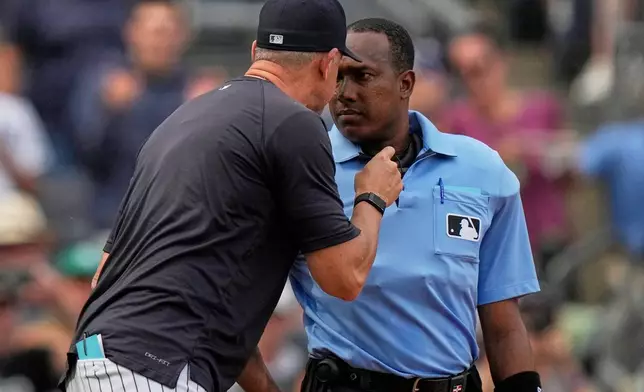 Home plate umpire Ramon de Jesus listens to New York Yankees manager Aaron Boone argue a call during the fifth inning of a baseball game against the Baltimore Orioles Saturday, Sept. 27, 2025, in New York. (AP Photo/Frank Franklin II)