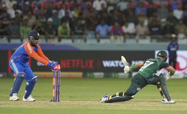 India's Sanju Samson, left, attempts unsuccessfully to stump Pakistan's Sahibzada Farhan during the Asia Cup cricket match between India and Pakistan at Dubai International Cricket Stadium in Dubai, United Arab Emirates, Sunday, Sept. 21, 2025. (AP Photo/Altaf Qadri)