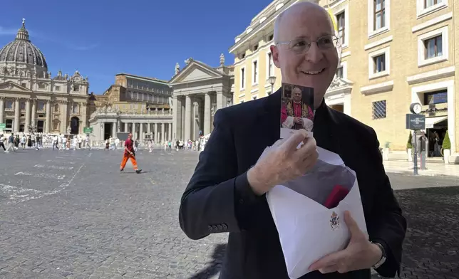 Rev. James Martin, a New York-based Jesuit, shows a commemorative photograph of Pope Leo XIV during an interview with The Associated press just outside St. Peter's Square in Rome, Monday, Sept. 1, 2025. (AP Photo/Maria Selene Clemente)