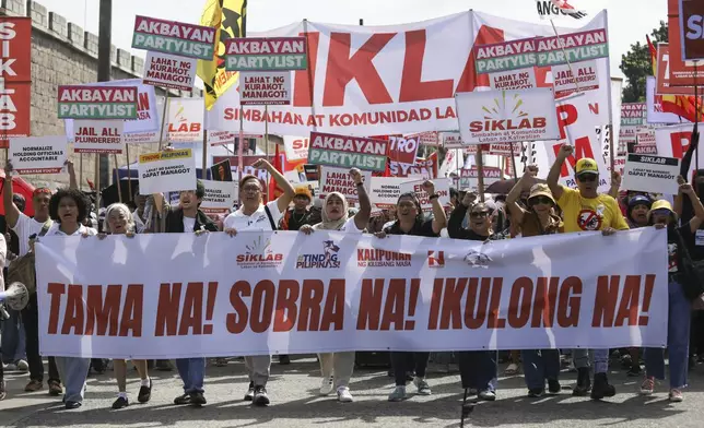 Protesters carry signs as they march during a rally against government corruption at the EDSA People Power Monument in suburban Mandaluyong, east of Manila, Philippines, Sunday. Sept. 21, 2025. (AP Photo/Basilio Sepe)