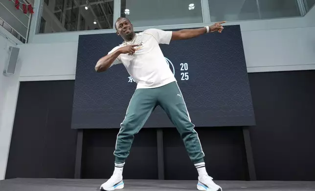 Former sprinter, Jamaica's Usain Bolt makes his signature pose at the end of a press conference ahead of the World Athletics Championships in Tokyo, Japan, Thursday, Sept. 11, 2025. (AP Photo/Eugene Hoshiko)