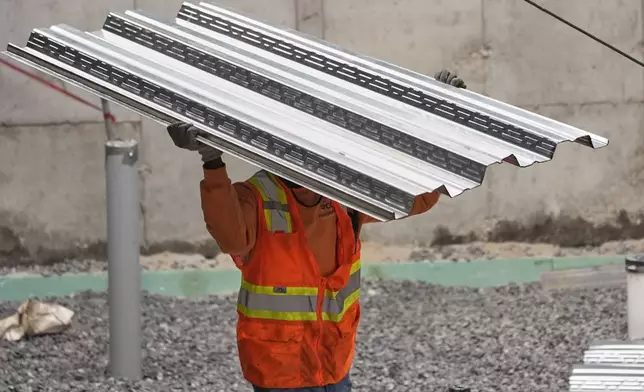 FILE - A construction worker carries steel decking at the site of a construction of a housing project, Thursday, July 31, 2025, in Portland, Maine. (AP Photo/Robert F. Bukaty, File)