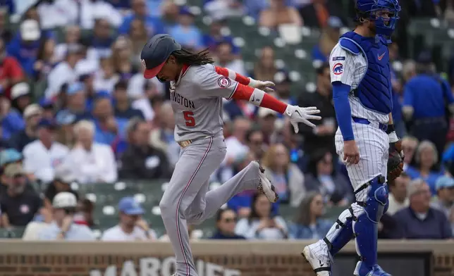 Washington Nationals' CJ Abrams (5) runs by Chicago Cubs catcher Carson Kelly (15) to score on a single from Washington Nationals catcher Jorge Alfaro (44) during the first inning of a baseball game Saturday, Sept. 6, 2025, in Chicago. (AP Photo/Erin Hooley)