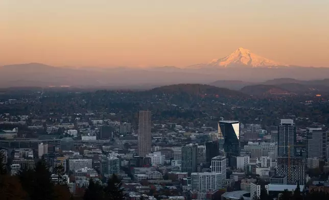 FILE - With Mount Hood in the background, the sun sets over downtown Portland, Ore., on Wednesday, Nov. 6, 2024. (AP Photo/Jenny Kane, File)