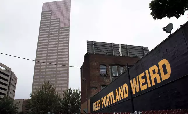 FILE - A downtown building displays a popular slogan in relation to the city in Portland, Ore., Sept. 19, 2012. (AP Photo/Don Ryan, File)
