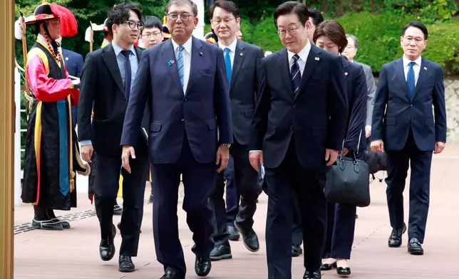 South Korean President Lee Jae Myung, center right, and Japanese Prime Minister Shigeru Ishiba, center left, arrive to hold a meeting in Busan, South Korea, Tuesday, Sept. 30, 2025. (Yonhap via AP)