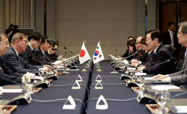 South Korean President Lee Jae Myung, second from right, talks with Japanese Prime Minister Shigeru Ishiba, second from left, during a meeting in Busan, South Korea, Tuesday, Sept. 30, 2025. (Yonhap via AP)