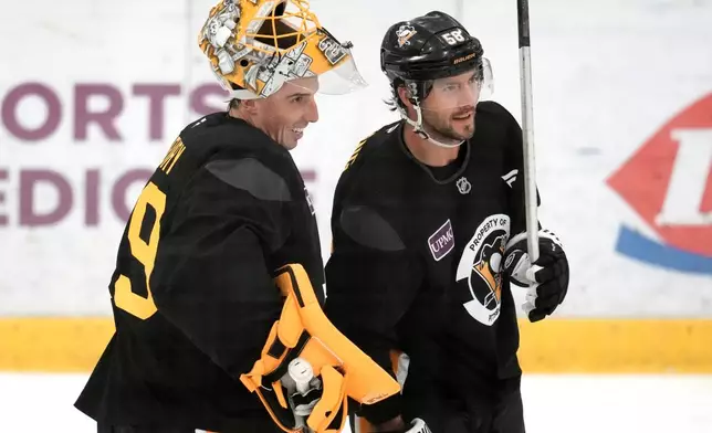 Pittsburgh Penguins goalie Marc-Andre Fleury, left, and Kris Letting take a break during the NHL hockey team's pre-game skate in Cranberry Township, Pa., Friday, Sept. 26, 2025. (AP Photo/Gene J. Puskar)