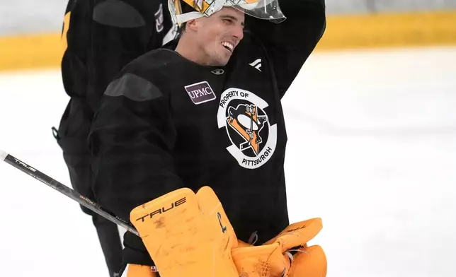 Pittsburgh Penguins goalie Marc-Andre Fleury, front, and Evgeni Malkin take a break during the NHL hockey team's pre-game skate in Cranberry Township, Pa., Friday, Sept. 26, 2025. (AP Photo/Gene J. Puskar)