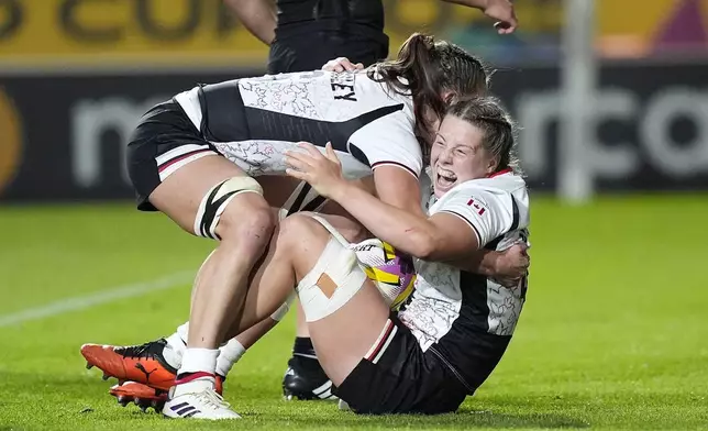 Canada's Sophie de Goede, right, celebrates with team-mates after scoring a try during the Women's Rugby World Cup 2025 semifinal match between Canada and New Zealand at Ashton Gate, Bristol, England, Friday Sept. 19, 2025. (Andrew Matthews/PA via AP)