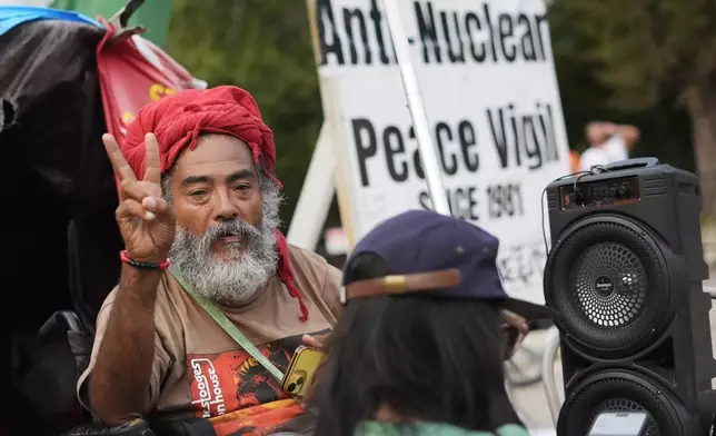 Philipos Melaku-Bello gestures the peace sign at the White House Peace Vigil in Lafayatte Park across the street from the White House in Washington, Friday, Sept. 5, 2025. (AP Photo/Pablo Martinez Monsivais)