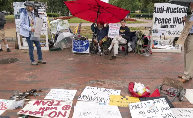 Philipos Melaku-Bello, center left, and Will Rosin, center right, flash the V sign during Peace Vigil in Lafayette Park across from the White House in Washington, Sunday, Sept. 7, 2025. The U.S. (AP Photo/Jose Luis Magana)